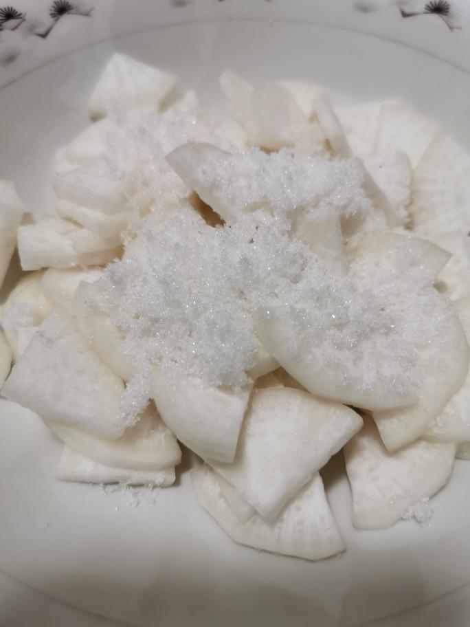白萝卜切片,第一遍用糖杀出水份,第二遍用盐杀出水份,攥干水份